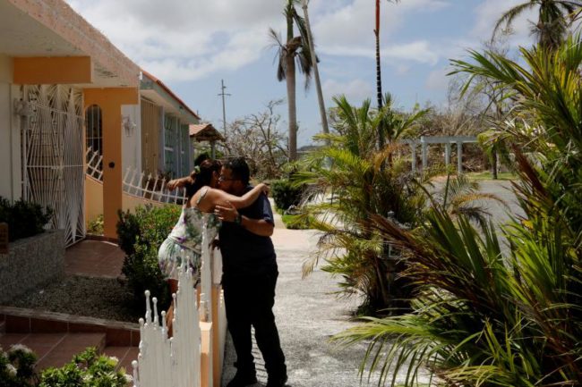 A resident reacts after being given food and water by a volunteer as recovery efforts continue following Hurricane Maria in Ceiba
